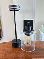 Table lamp and wall sconce side by side on table