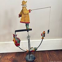 Full view of fisherman sculpture on stand