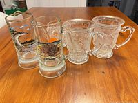 Five handled glass and crystal mugs on table