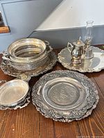 Overview of silver-plated trays, strainer bowl, oval tray, coffee pot and oil lamp