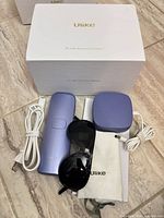 Full lot with handset, power adapter, USB cable, sunglasses, pouch in front of original box