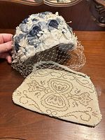 Fascinator hat and beaded purse on wood surface
