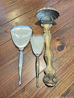 hand mirror, hair brush and shell scoop on floor