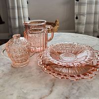 Entire 5-piece pink depression glass set on tabletop