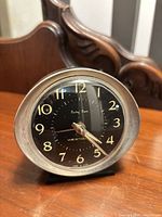 Front view of Westclox Baby Ben alarm clock on wooden surface