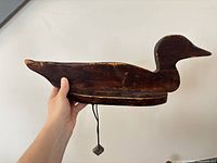 Left-facing profile of wooden duck decoy