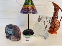 Group shot showing all four items: Tiffany-style lamp, glass owl, lady face sculpture, pitcher vase