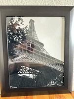 Front view showing Eiffel Tower black & white print in black frame under glass