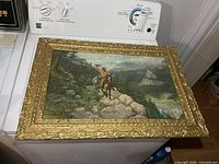 Front view of ornate gilt frame with print