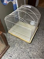 Front angled view of white wire bird cage on floor