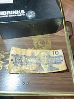 Money box top view with $10 bill front showing Macdonald