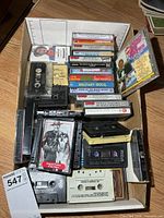 Tray overview showing cased and loose cassette tapes plus CD
