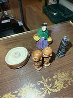 All items on table: figurine, totem, tiki shakers, hedgehog dish