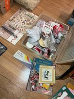 Overview of lot showing oil pastel set, scrapbooking books, alphabet stickers and open tote of ribbon