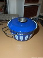 Side view of blue enamel pot showing lotus pattern and lid