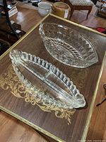 Both glass serving dishes on table: divided relish tray and diamond pattern bowl