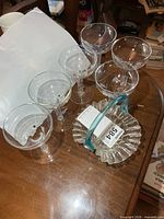 Six hollow stem glasses and fluted candy dish displayed on table