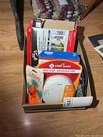 Boxed lot showing all packaged items including smoke alarm, whistle, sealing strip, window kit, footwear traction