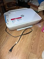 HP DeskJet 2652 printer with power cord on floor