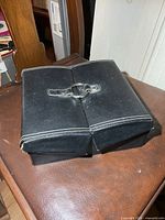 Closed black jewellery case on chair