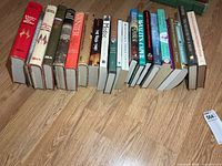 Full row of roughly twenty-two hardcovers showing page edges and general condition.