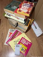 Stack of assorted novels and humor books showing variety of titles
