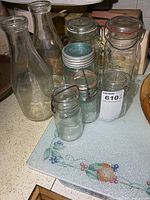 Group view showing two milk bottles and four sealer jars