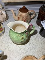 Green floral pitcher front with Wade Brumble teapot in background