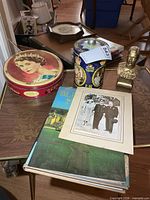 Lot overview showing both tins, bust, book, photo