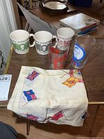 Overview showing three mugs, two glasses, printed flag napkin