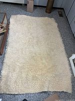 Full view of cream wool sheepskin bed cover laid flat