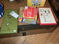 Three boxed stationery sets and journals on trunk