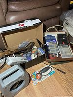 Overview of boxes containing hardware organizers, extension cord and assorted items