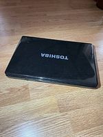 Closed Toshiba laptop showing lid logo