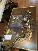 overview of lot on table showing cutlery in bag, loose serving pieces, crumb tray and sweeper