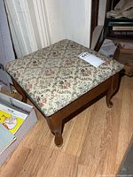 Oblique view showing full footstool, wood frame, patterned upholstery