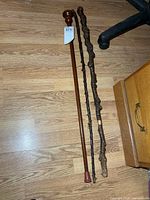 Three walking sticks laid side by side on floor