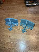 Both light blue wooden wall shelves showing design and size