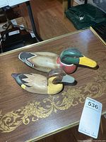Two painted wooden duck figures on table