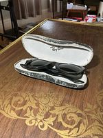 Sunglasses inside open Ray-Ban case on table
