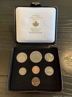 Open presentation case showing seven coins inside