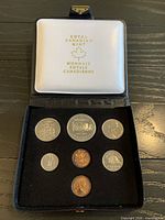 Full set in open case showing six coins and interior lid logo