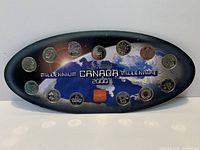 Front view of oval display showing 12 coins and token