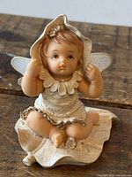Front view of resin baby fairy figurine on leaf base