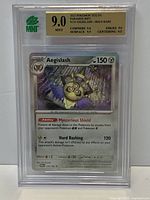 Front of MNT-slabbed Aegislash card with grade 9.0 label
