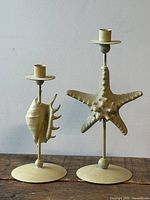 Front view of both candle holders showing starfish and shell motifs