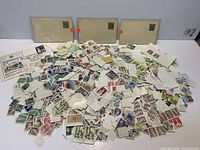 Pile of loose stamps with several envelopes and covers visible
