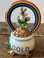 Full view of figurine showing rabbit, rainbow, pot of gold