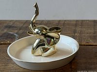 Front view of white dish and gold elephant ring holder