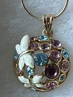 Close-up of pendant showing enamel butterflies and multicolour crystals